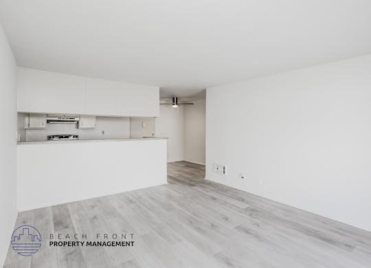 A spacious room with a logo for Beach Front Property Management in the bottom left corner.