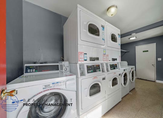 A stack of white front load washing machines in a laundry room.