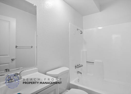 a white bathroom with a tub and a toilet and a sink