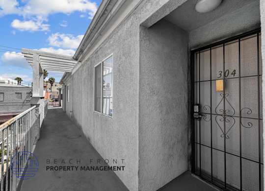 A balcony of a building with a glass door and a number 304 on it.