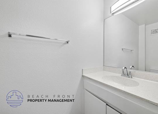 A bathroom with a white sink and mirror.