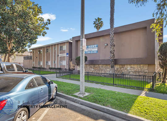A car is parked in front of a building with a sign that says