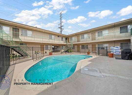 A pool in a courtyard surrounded by apartment buildings.