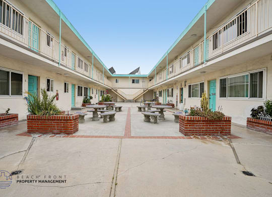 A courtyard with tables and chairs surrounded by buildings.