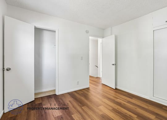 A room with white doors and wooden floors.