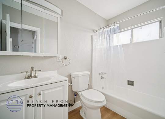 A white bathroom with a toilet, sink, and bathtub.