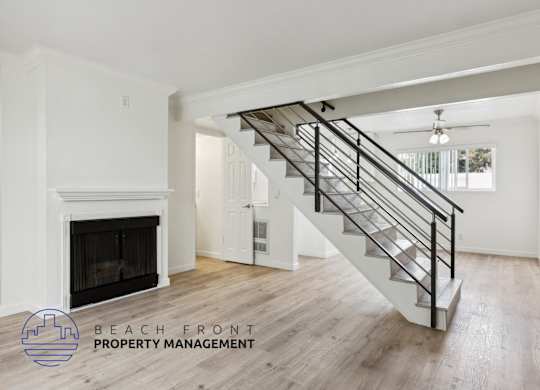 A spacious room with a staircase leading to the upper floor.