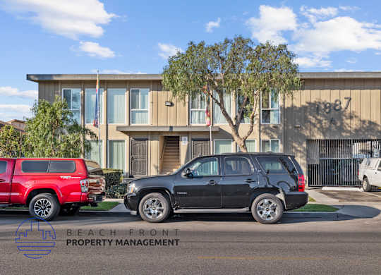 A black SUV is parked in front of a building with the number 1987 on it.