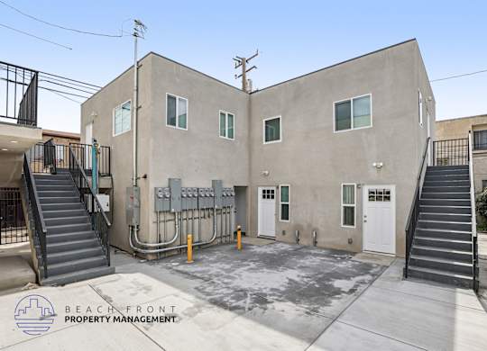 A concrete building with a staircase leading to the entrance.