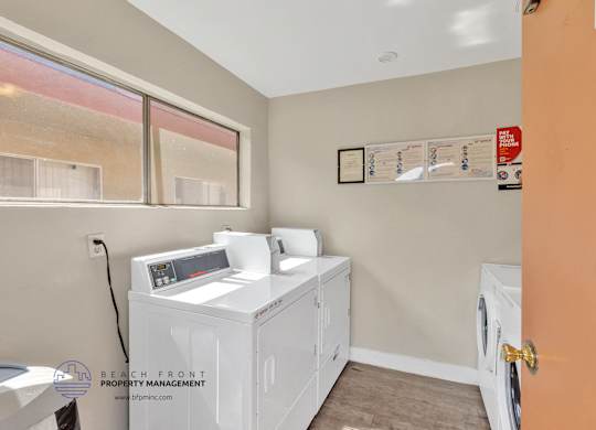 A laundry room with a washer and dryer, a window, and a sign that says