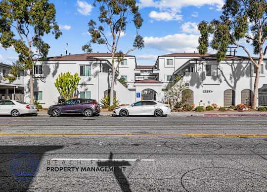 A street view with cars and apartment buildings.