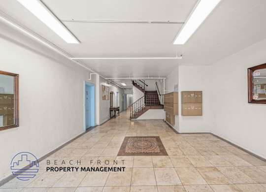A hallway with a logo for Beach Front Property Management.