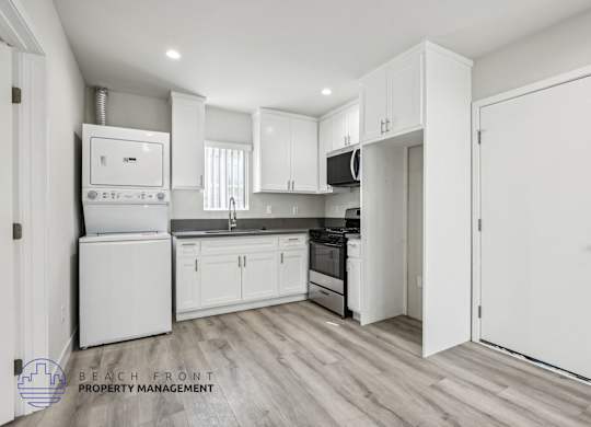 A kitchen with white appliances and cabinets.