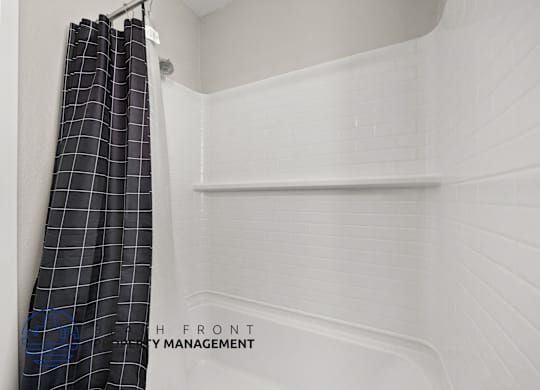 A white bathroom with a shower curtain and a sign that says "Front".