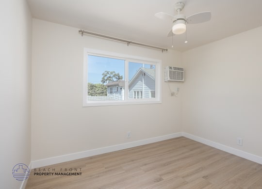 A room with a window showing a house outside.