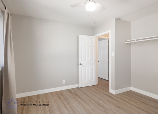 A room with a door and a wall with a shelf.