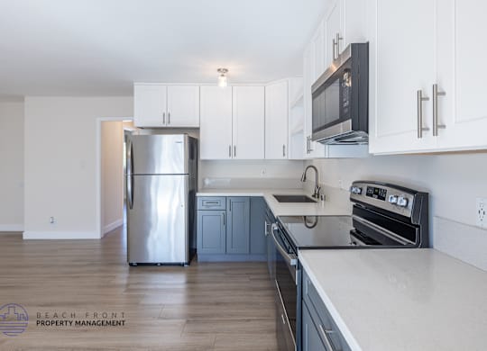 A kitchen with a stainless steel refrigerator, oven, and microwave.