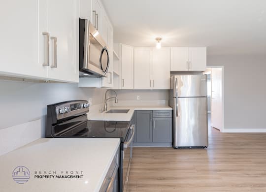 A kitchen with white cabinets and a stainless steel refrigerator.