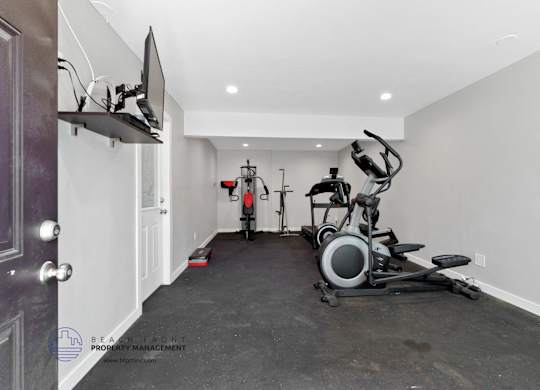 A home gym with a stationary bike and a rowing machine.