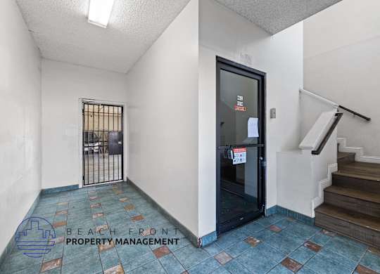 the entrance to the lobby of a building with stairs and a glass door