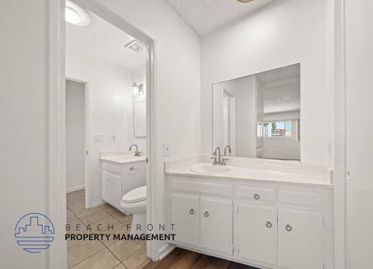 A bathroom with a sink, toilet, and mirror.