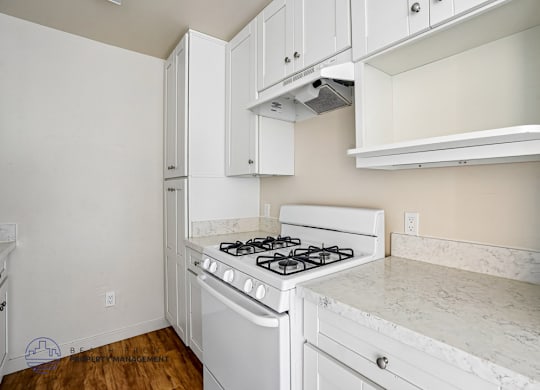 A white kitchen with a stove and cabinets.