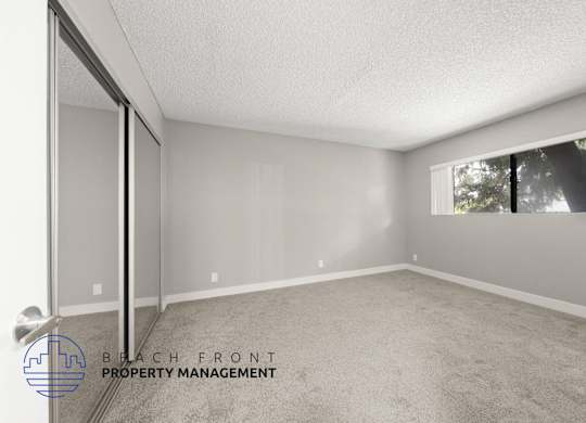 the spacious living room of a manufactured home with carpet and a large window