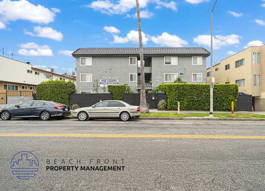 A street view with cars parked and a building with the sign