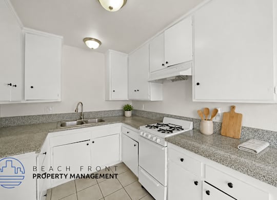 A kitchen with white cabinets and a granite countertop.