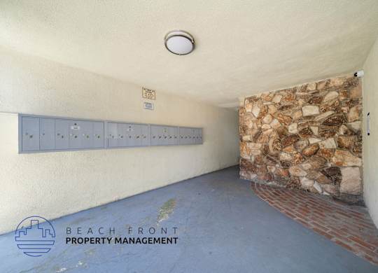 A room with a stone wall and a row of lockers.