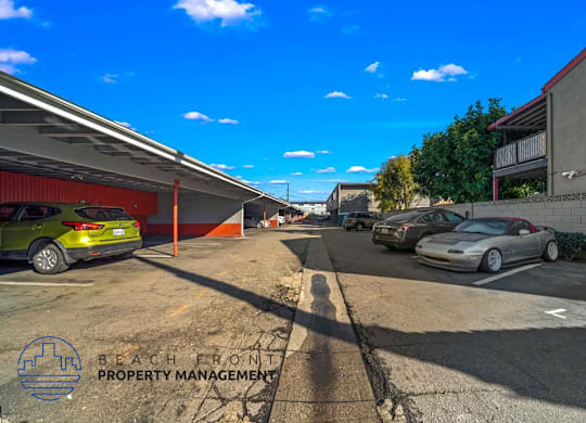 A parking lot with cars and a building in the background.