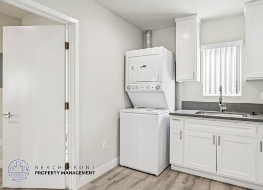 A white kitchen with a washer and dryer built in.