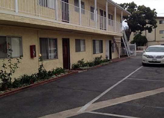A car is parked in a parking lot in front of a building.