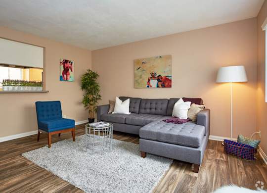 a living room with a gray couch and a blue chair