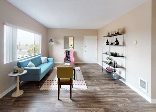 a living room with a blue couch and a table with a yellow chair