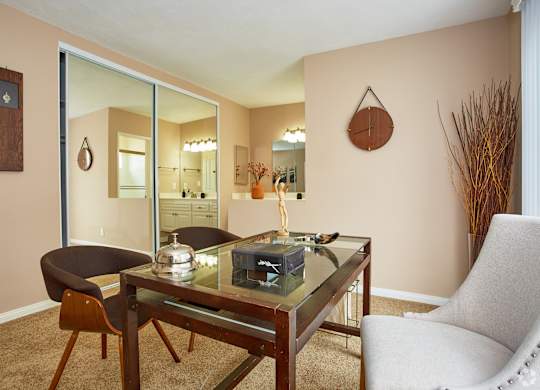 a living room with a glass table and two chairs