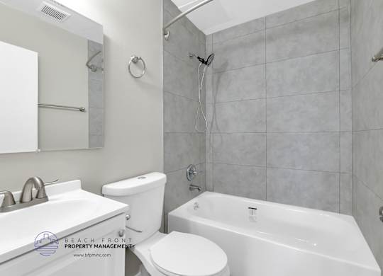 A white bathroom with a toilet, sink, and bathtub.