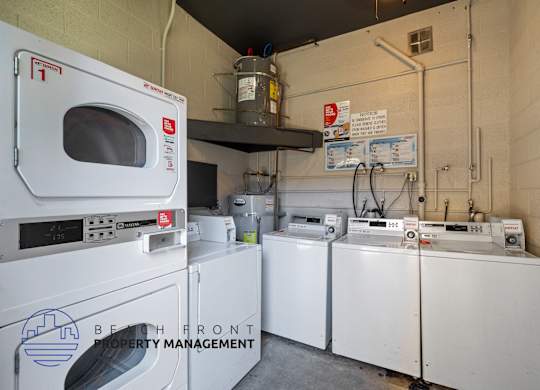 A laundry room with washers and dryers and a sign that says