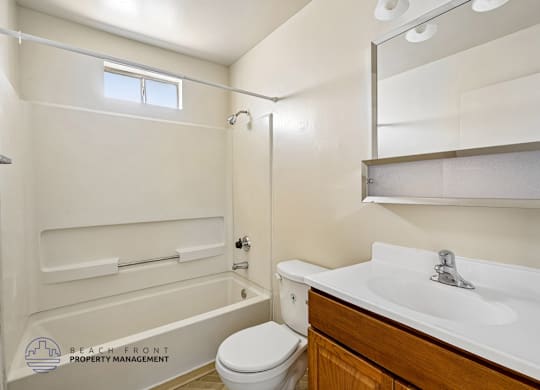 A white bathroom with a toilet, sink, and bathtub.