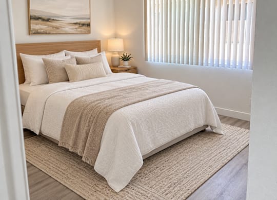 A bedroom with a large bed and a painting on the wall.