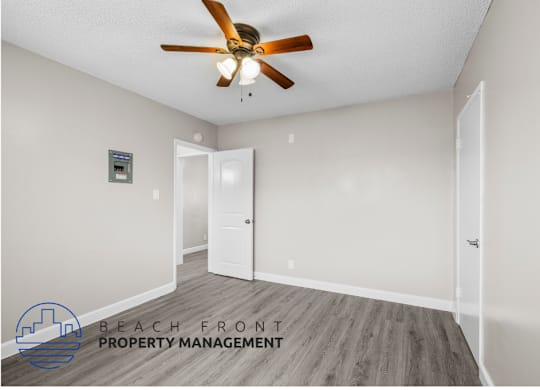 an empty room with a ceiling fan and a door