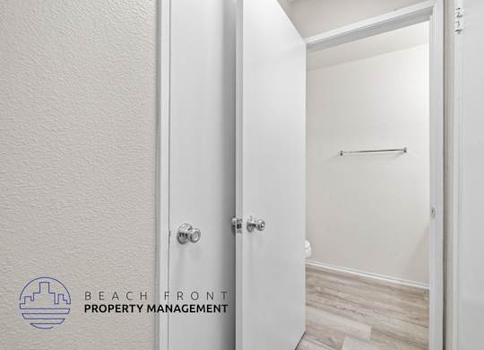 A white door with a handle and a logo of Beach Front Property Management on the bottom left.