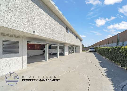 A white building with a sign that says Beach Front Property Management.
