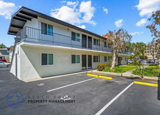 an apartment building with a parking lot and a balcony