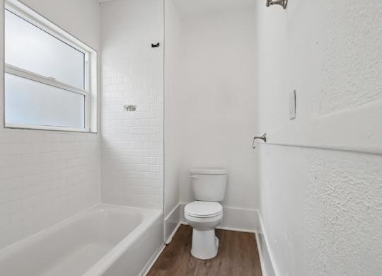 A white bathroom with a toilet and a bathtub.