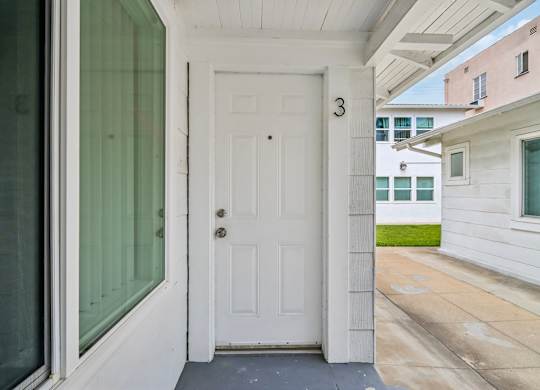 A white door with a number 3 on it is the entrance to a home.