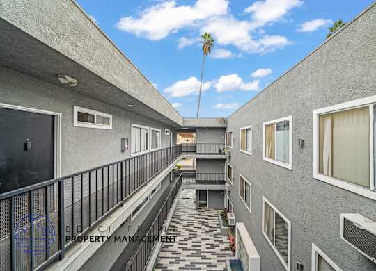 A balcony with a black railing and a tiled floor.