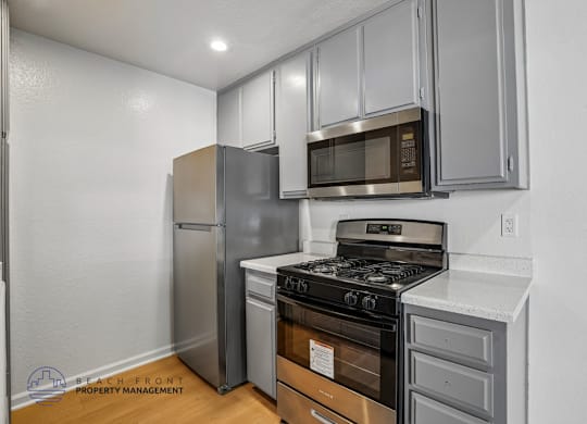 A kitchen with a stove, oven, refrigerator, and microwave.