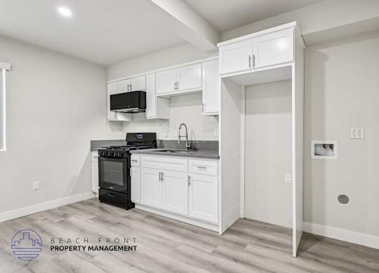 A kitchen with white cabinets and a black stove top oven.