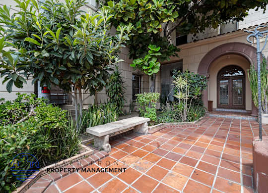 a courtyard with a bench and plants in front of a building